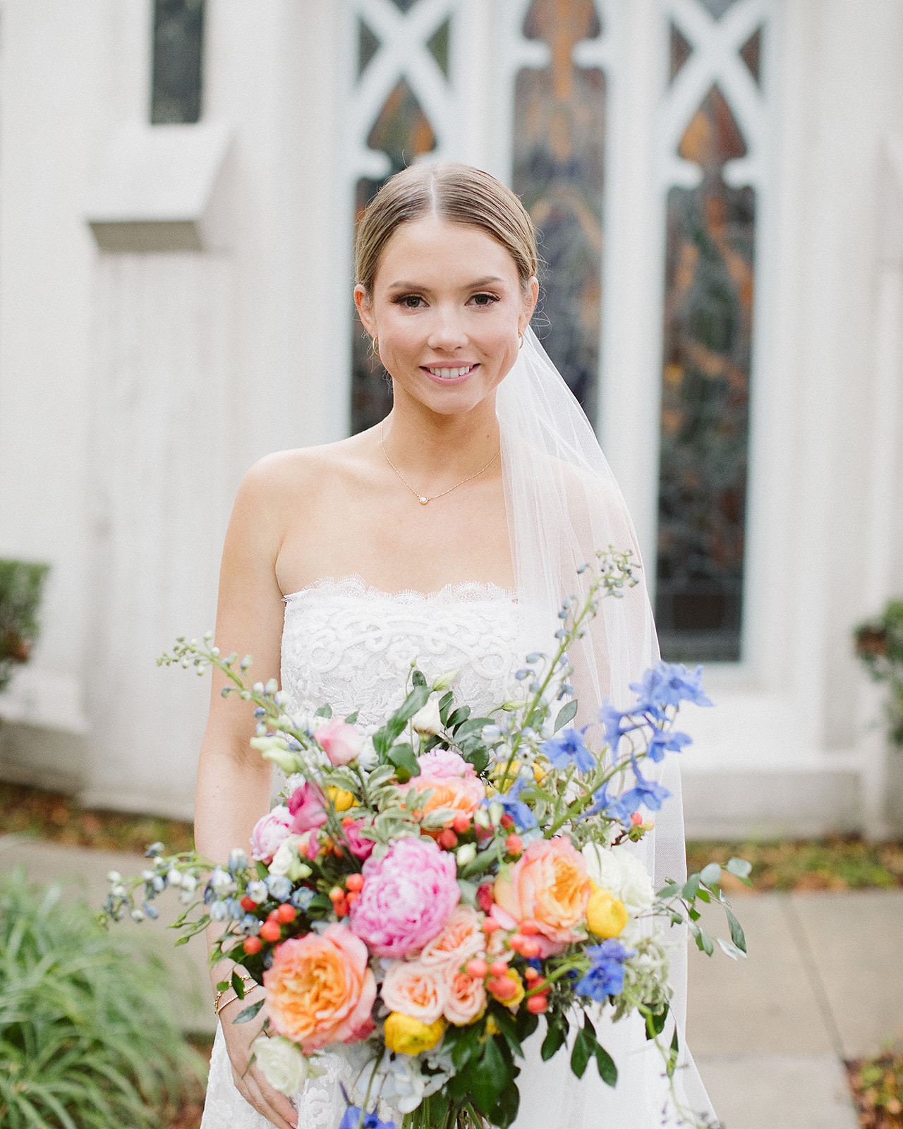 Bride holding colorful wedding bouquet outdoors