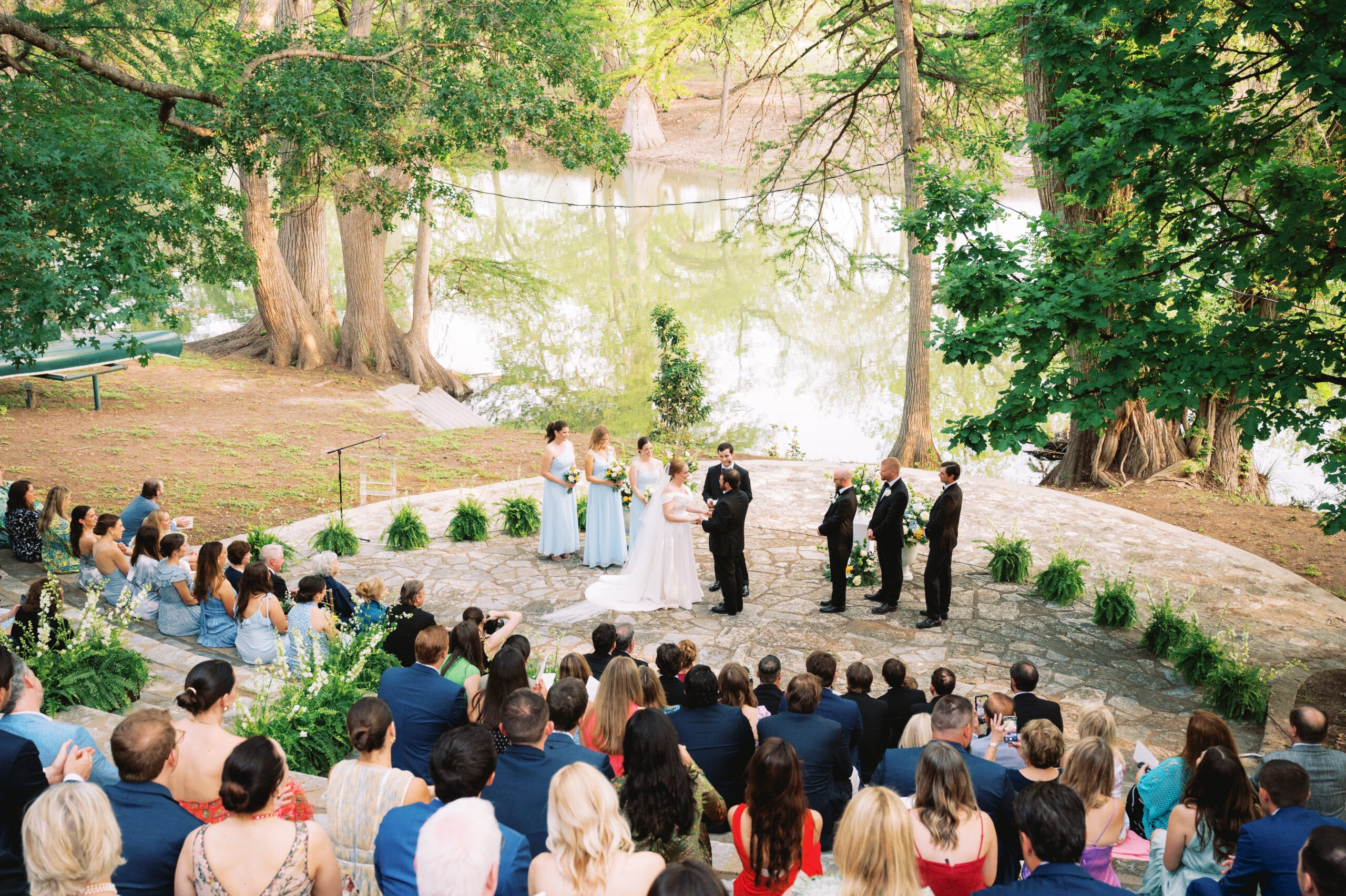 Outdoor wedding ceremony with guests and greenery